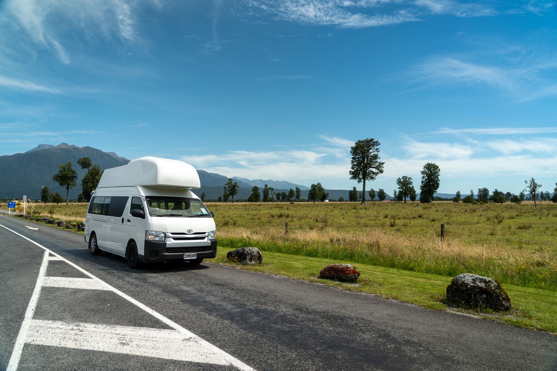 Custom campervan parked in pristine New Zealand nature landscape